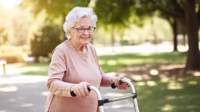 Mujer anciana usa andador en parque