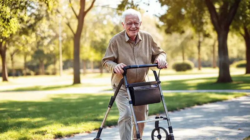 Un anciano feliz camina cómodamente en el parque